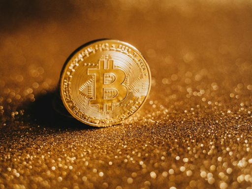 Detailed close-up of a Bitcoin on a glittery gold background, symbolizing digital finance.