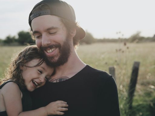 man carrying daughter in black sleeveless top