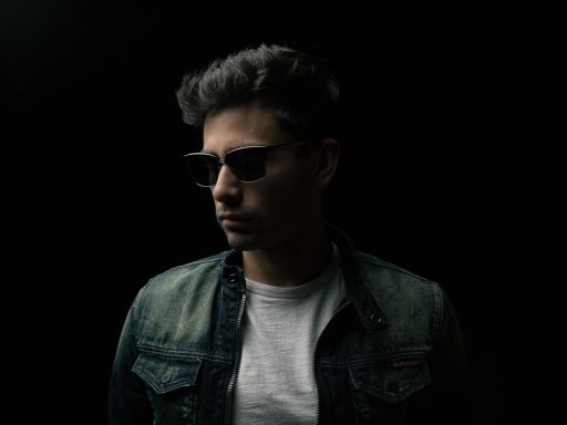Man die twijfelt bij de kapstok tussen een bodywarmer en een jas