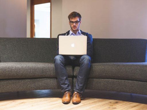 Jonge man die zijn financiën bekijkt op een laptop aan een bureau