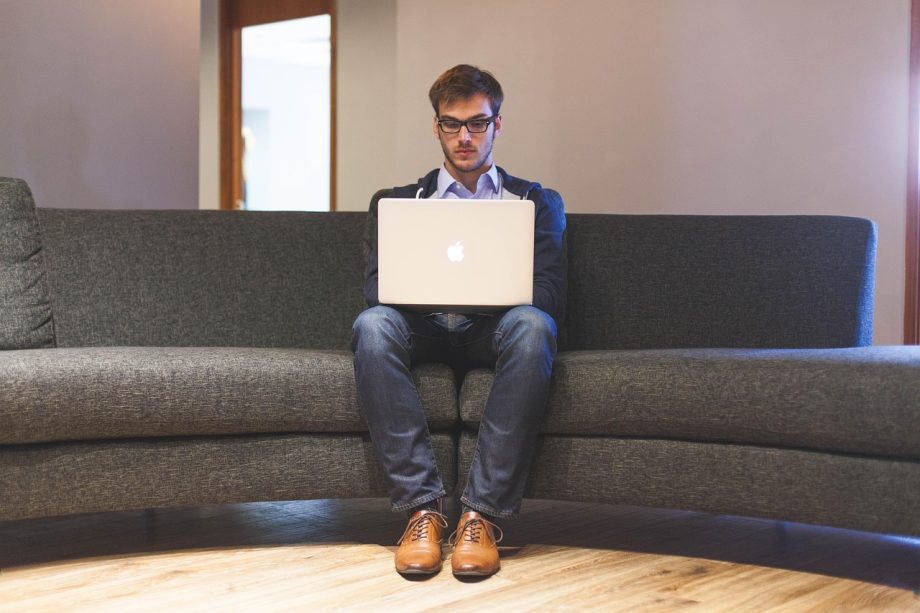 Jonge man die zijn financiën bekijkt op een laptop aan een bureau