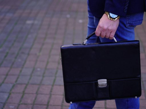 Man met een leren messenger bag over zijn schouder in stedelijke omgeving