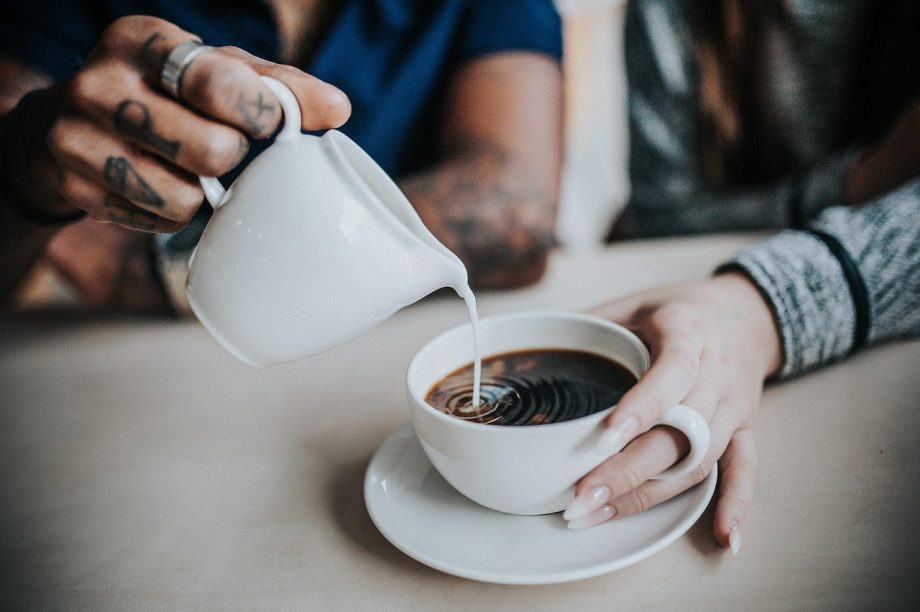 Man in antracietkleurige badjas aan de ontbijttafel met een kop koffie