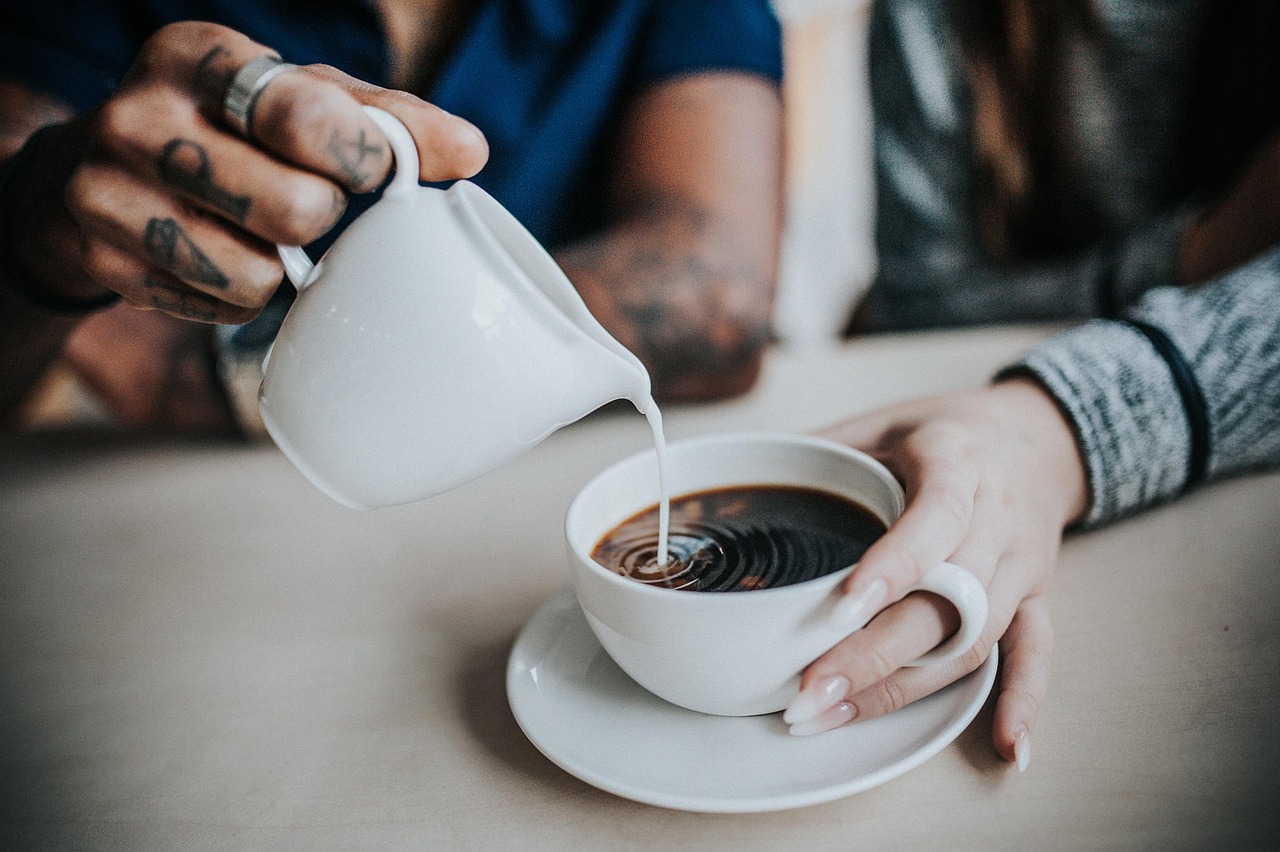 Man in antracietkleurige badjas aan de ontbijttafel met een kop koffie