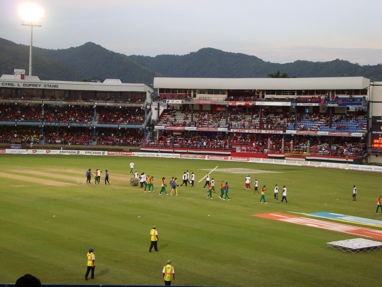 Volle cricketstadion tijdens een T20-wedstrijd met kleurrijk publiek op de tribunes