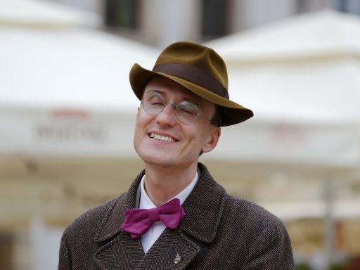 Man in een wollen overjas die een kwaliteitsjas bekijkt in een winkel
