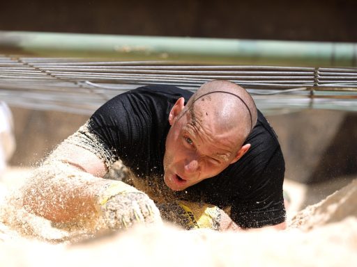 Krachtsporter tilt een zware atlas stone tijdens een strongman training