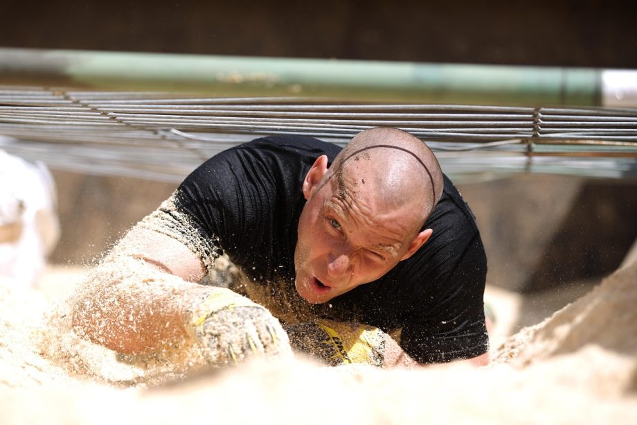 Krachtsporter tilt een zware atlas stone tijdens een strongman training